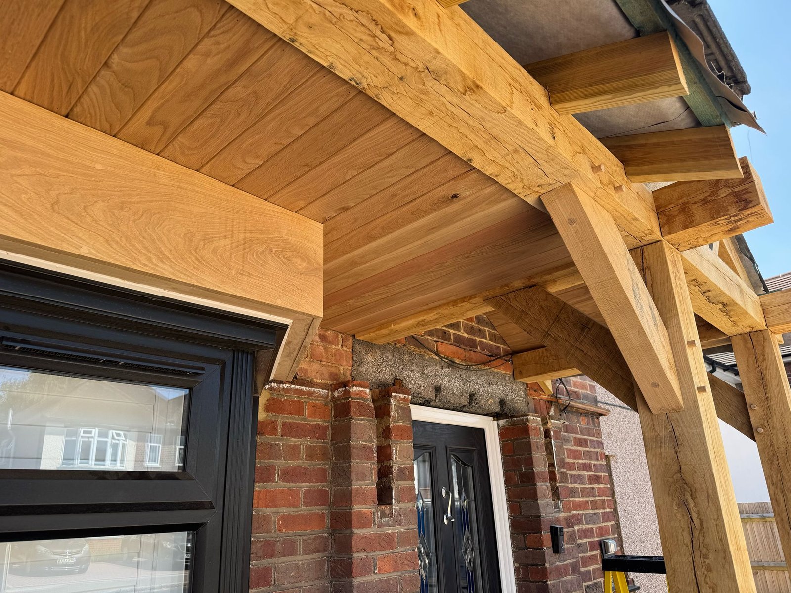 Angled view oak frame porch with brick walls below