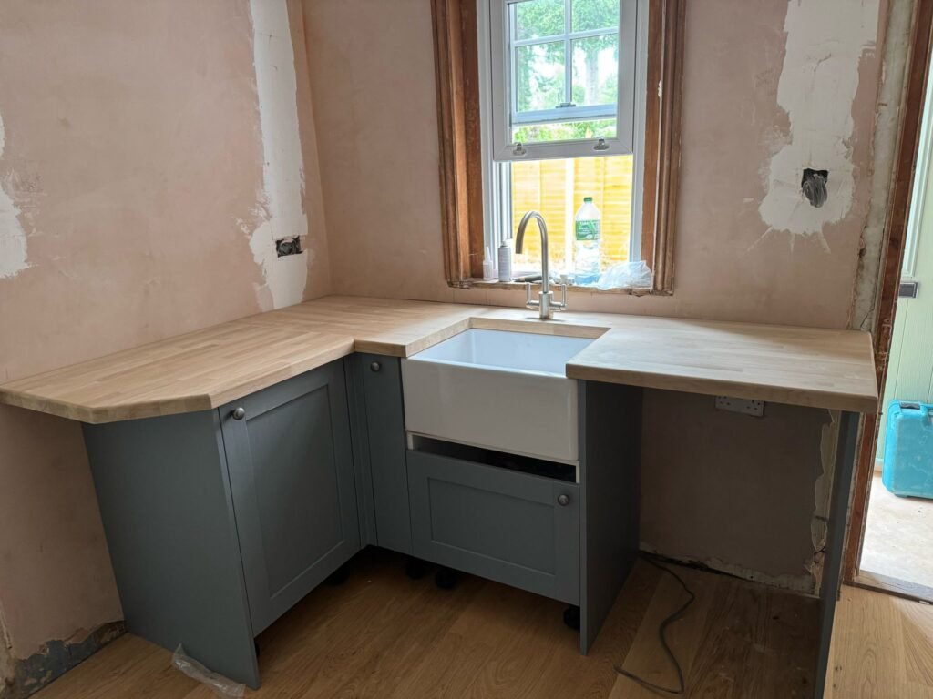 Farmhouse sink with oak worktop and grey cabinets