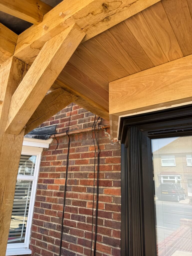 Underside view oak porch ceiling with exposed timber beams